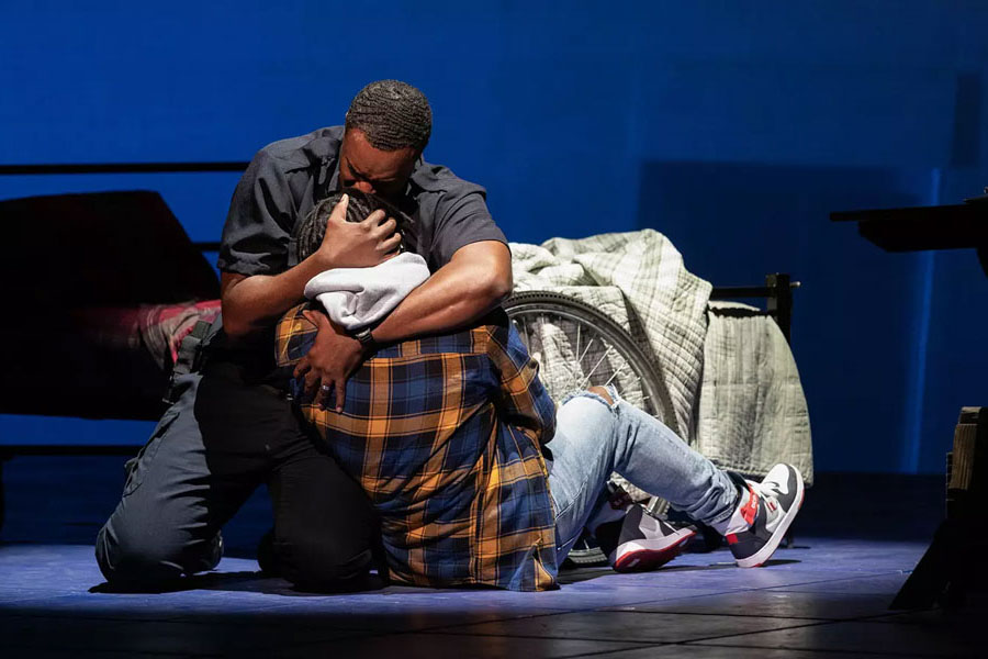 Photo of two people embracing from stage production of 'Blue'